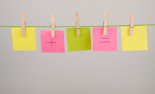 Veelkleurige papieren hangen op de waslijn tegen een witte achtergrond