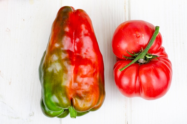 Foto veelkleurige paprika's en tomaten op houten tafel. studiofoto.