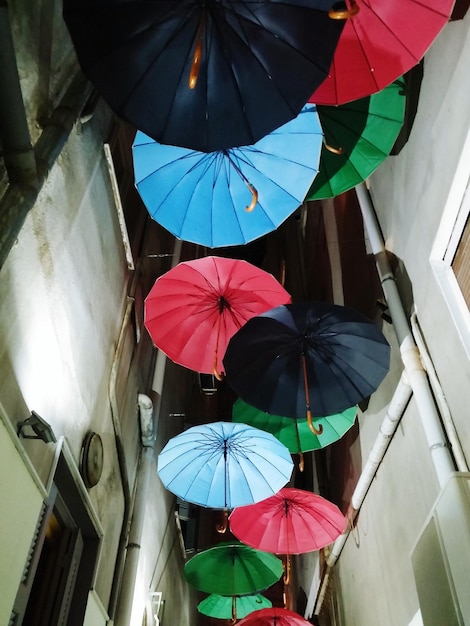 Veelkleurige paraplu's in de lucht tussen gebouwen