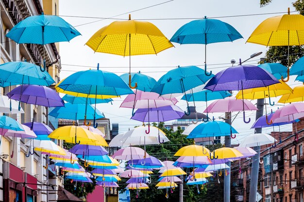 Veelkleurige parasols in de stad op straat. De stadsstraat is versierd met parasols