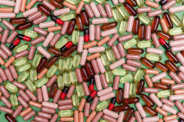 Veelkleurige pillen en capsules op een groene achtergrond