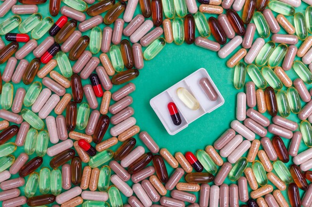 Veelkleurige pillen en capsules op een groene achtergrond