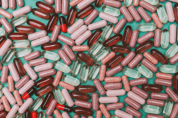Veelkleurige pillen en capsules op een groene achtergrond