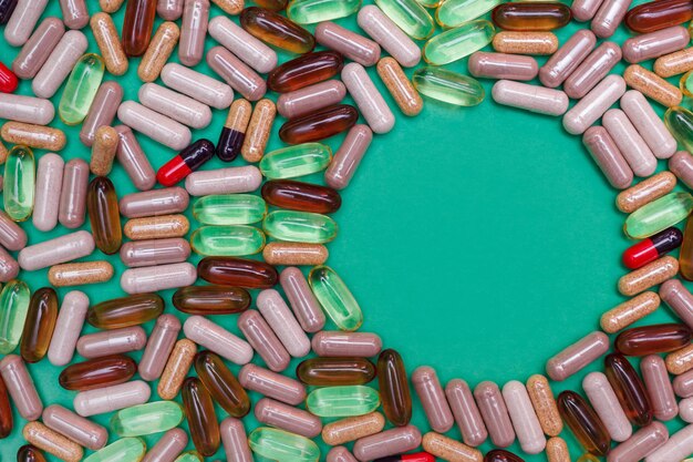 Veelkleurige pillen en capsules op een groene achtergrond