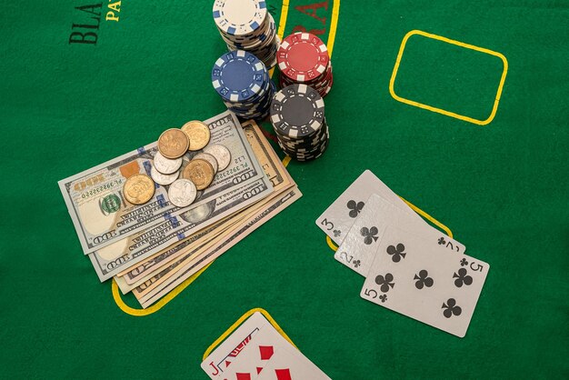 Veelkleurige pokerkaarten chips dollarbankbiljetten neergelegd op een nieuwe groene pokertafel Pokerconcept Opwindingsconcept