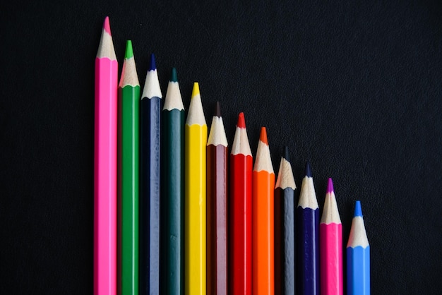 Veelkleurige potloden op een zwarte achtergrond