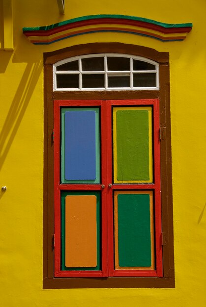 Foto veelkleurige ramen op een gele muur.