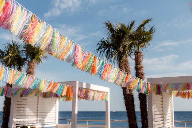 Foto veelkleurige slingers met franjes op een zomerse strandachtergrond