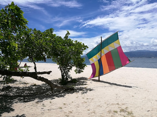 Foto veelkleurige vlag op het strand tegen de lucht