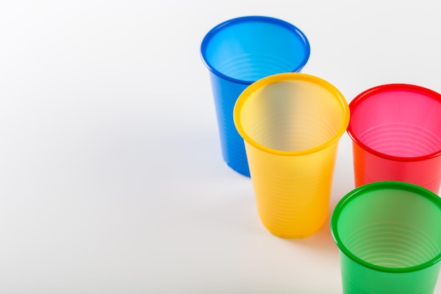 Veelkleurige wegwerp plastic glazen geïsoleerd op een witte achtergrond