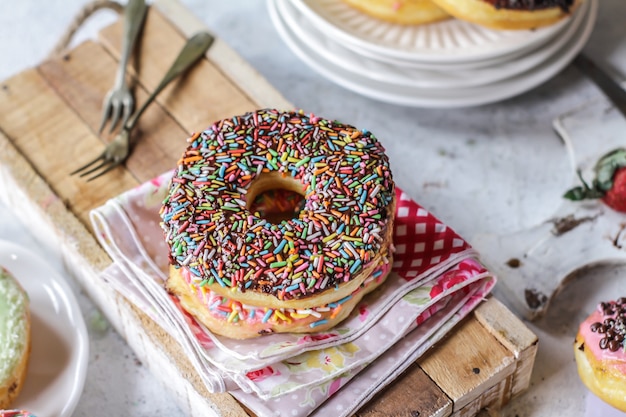 Veelkleurige zoete donut met gekleurde hagelslag op houten oppervlak