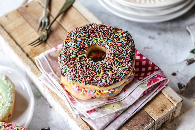 Veelkleurige zoete donuts met gekleurde hagelslag op houten oppervlak