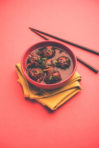 Veg or chicken Manchurian with gravy - Popular food of India served in a bowl with chopstick