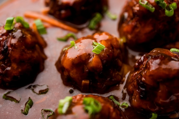 Veg or chicken Manchurian with gravy - Popular food of India served in a bowl with chopstick