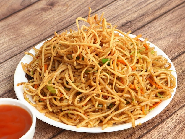 Veg Hakka Noodles een populair oosters gerecht gemaakt met noedels en groenten geserveerd op een rustieke houten achtergrond selectieve focus