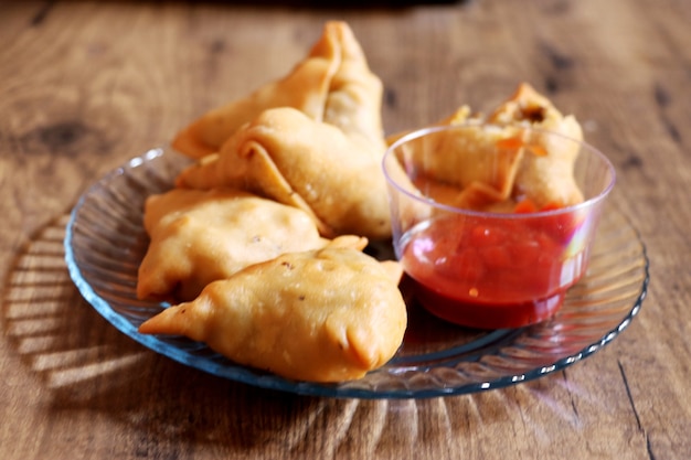 Veg Samosa - 마이다의 겉은 바삭하고 속은 으깬 감자, 완두콩, 향신료로 채워진 바삭하고 매운 인도 삼각형 모양의 스낵입니다.