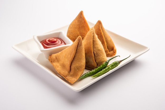 Veg Samosa - 마이다의 겉은 바삭하고 속은 으깬 감자, 완두콩, 향신료를 넣은 바삭하고 매운 인도 삼각형 모양의 스낵입니다.