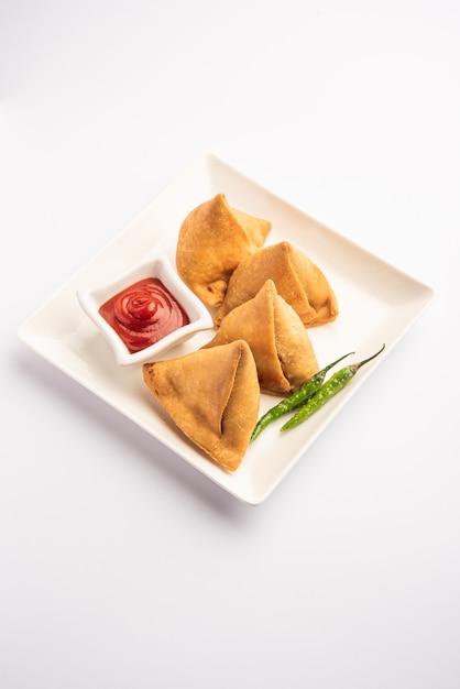 Veg Samosa - 마이다의 겉은 바삭하고 속은 으깬 감자, 완두콩, 향신료를 넣은 바삭하고 매운 인도 삼각형 모양의 스낵입니다.