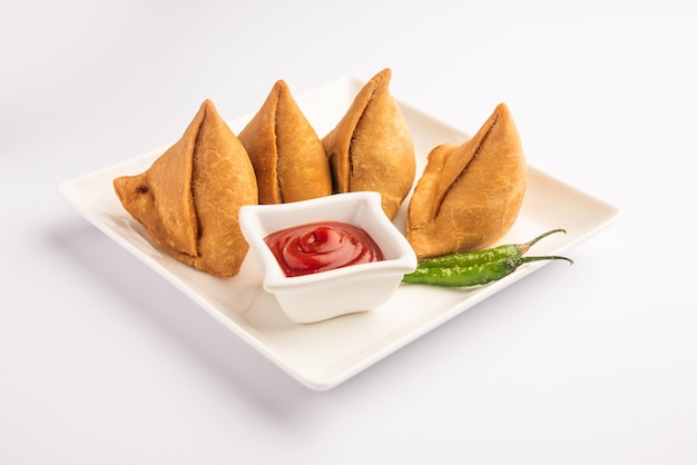 Veg Samosa - 마이다의 겉은 바삭하고 속은 으깬 감자, 완두콩, 향신료를 넣은 바삭하고 매운 인도 삼각형 모양의 스낵입니다.