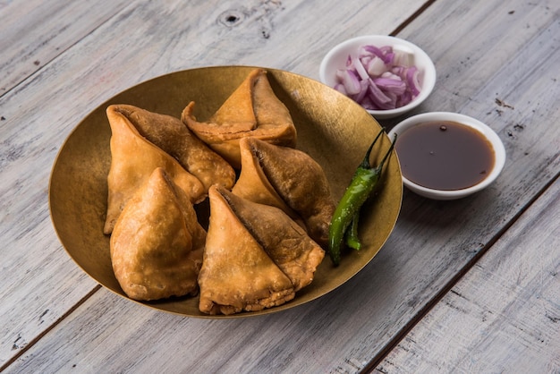 Veg Samosa - 파삭 파삭하고 매운 인도 삼각형 모양의 티 타임 스낵으로 튀긴 녹색 고추, 양파 및 처트니 또는 케첩과 함께 제공됩니다.