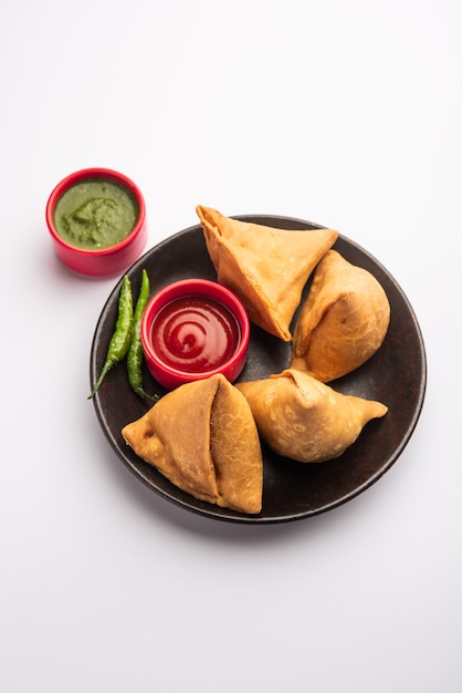 Veg Samosa - is een knapperige en pittige Indiase driehoekige snack met een knapperige buitenlaag van maida en een vulling van aardappelpuree, erwten en kruiden