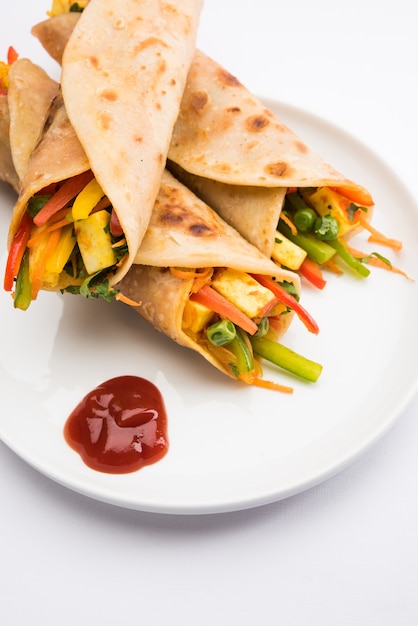 Chapati 또는 Roti 안에 채워진 Paneer와 야채를 사용하여 만든 Veg Spring Roll 또는 Wrap 또는 Franky. 토마토 케첩과 함께 제공됩니다. 선택적 초점
