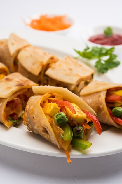 Chapati 또는 Roti 안에 채워진 Paneer와 야채를 사용하여 만든 Veg Spring Roll 또는 Wrap 또는 Franky. 토마토 케첩과 함께 제공됩니다. 선택적 초점