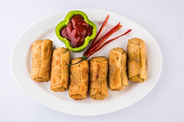 Veg Spring Rolls with mint leaf and green chutney or Tomato Ketchup. Selective focus