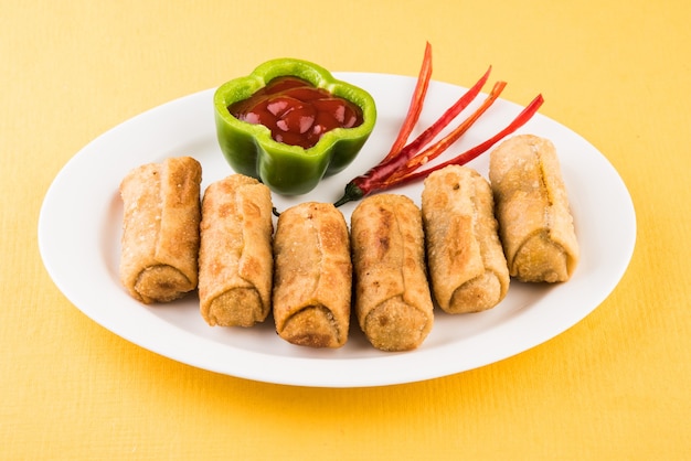 Veg Spring Rolls with mint leaf and green chutney or Tomato Ketchup. Selective focus