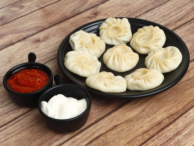 Veg steam momo Nepalese Traditional dish Momo stuffed with vegetables and then cooked and served with sauce over a rustic wooden background selective focus