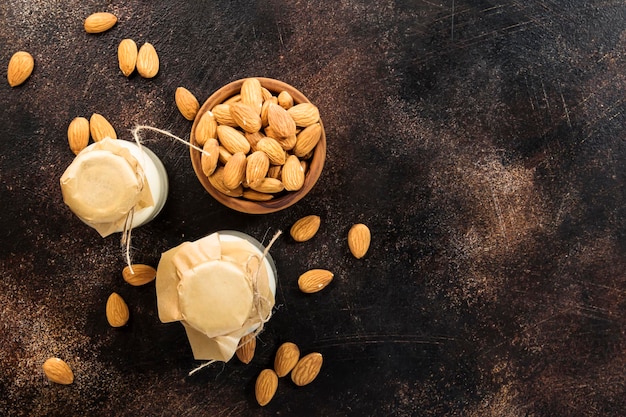 Vegan almond milk in bottles closeup brown background Non dairy alternative milk Healthy vegetarian food and drink concept Copy space Top view