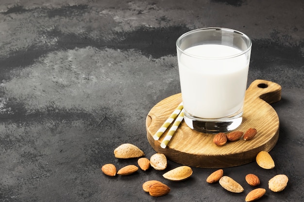 Vegan almond milk in glass on a dark background. Non-dairy milk. Copy space. Food background