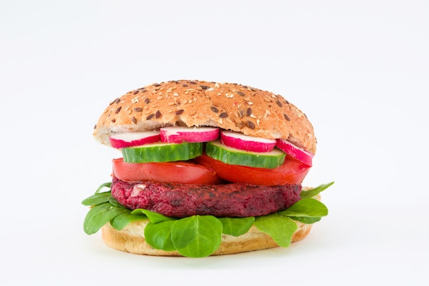 Vegan bietenburger met veldsla, tomaat, komkommer en radijs geïsoleerd