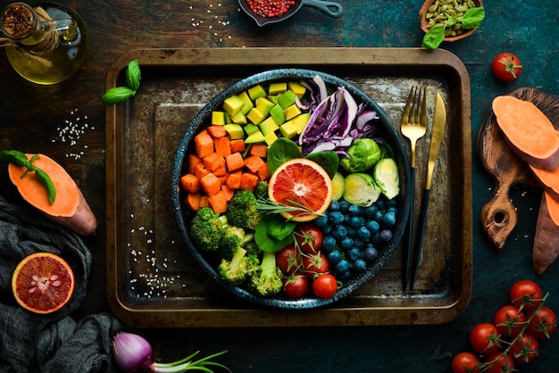 Vegan boeddha bowl zoete aardappelen bosbessen avocado's kool en sinaasappel dieetvoeding bovenaanzicht vrije ruimte voor uw tekst