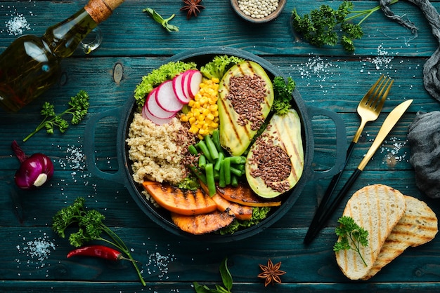 Vegan bowl quinoa avocado pumpkin with beans and corn in a black bowl Diet Top view Free space for text