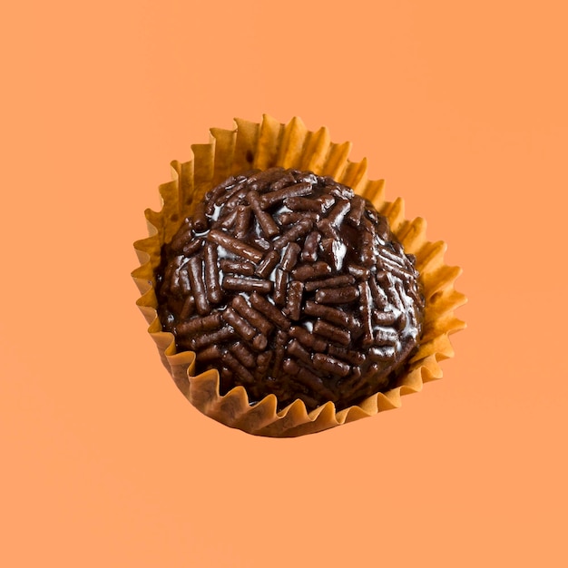 Vegan braziliaanse sweet genaamd brigadeiro chocoladeballen geïsoleerd op oranje achtergrond