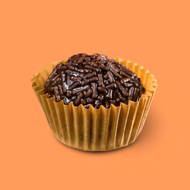 오렌지 배경에 격리된 Brigadeiro 초콜릿 공이라고 하는 채식주의 브라질 달콤한