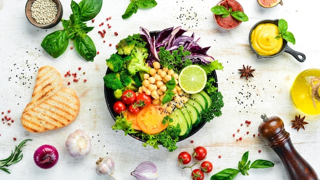 Vegan Buddha bowl chickpeas broccoli tomatoes and cucumber on a black stone plate Food Top view Free space for your text