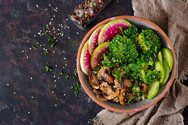 Vegan buddha bowl dinner food table.  Grilled mushrooms, broccoli, radish salad.