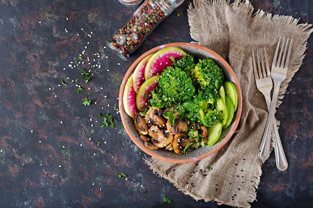 Vegan buddha bowl dinner food table. Healthy food. Healthy vegan lunch bowl. Grilled mushrooms, broccoli, radish salad. Flat lay. Top view.