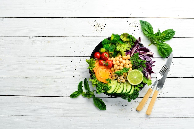 Vegan Buddha bowl kikkererwten broccoli tomaten en komkommer op een zwarte stenen plaat Voedsel Bovenaanzicht Vrije ruimte voor uw tekst