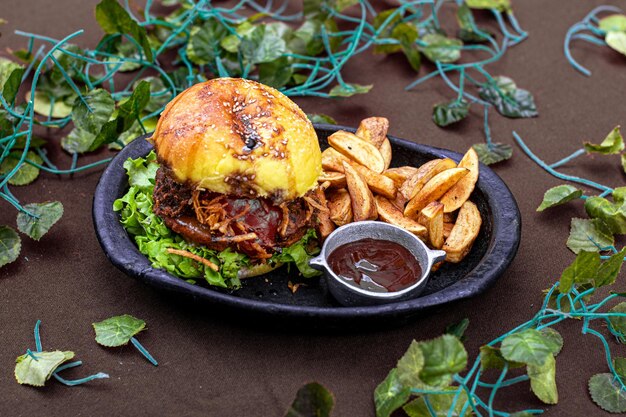 Foto un hamburger vegano con contorno di patatine fritte su un piatto