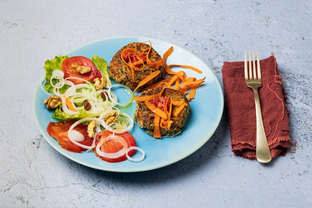 Vegan burgers and salad on a blue plate and blue background