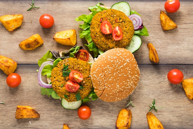 Hamburger vegani circondati da patate e pomodori