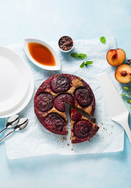 Vegan cake with fresh plums and maple syrup.