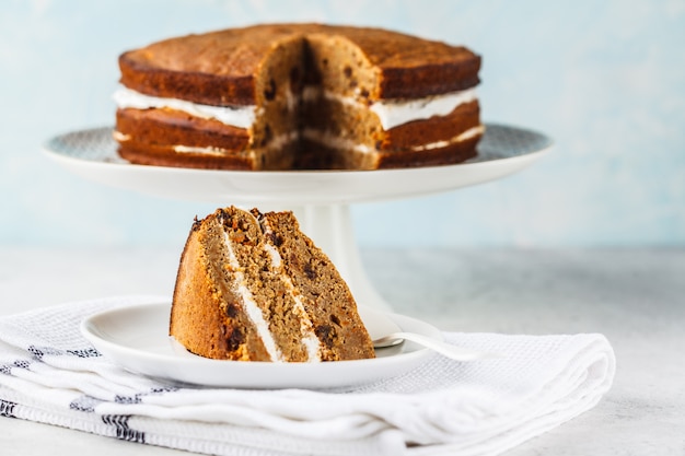 Vegan carrot cake with coconut cream, white background. 