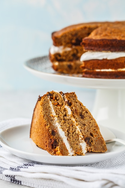 Vegan carrot cake with coconut cream, white background. 