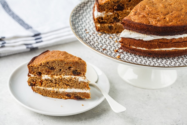 Vegan carrot cake with coconut cream, white background. 