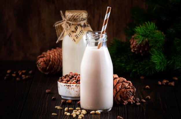 Vegan Cedar nut milk in bottles closeup wooden table background Non dairy alternative milk Healthy