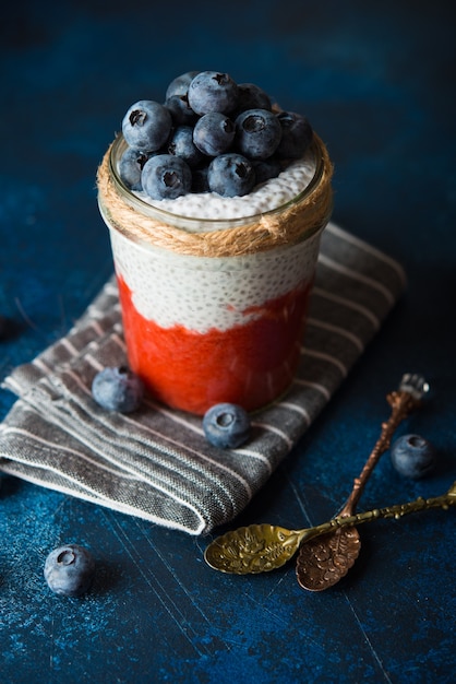 Vegan chia pudding with coconut milk and strawberry puree in a jar